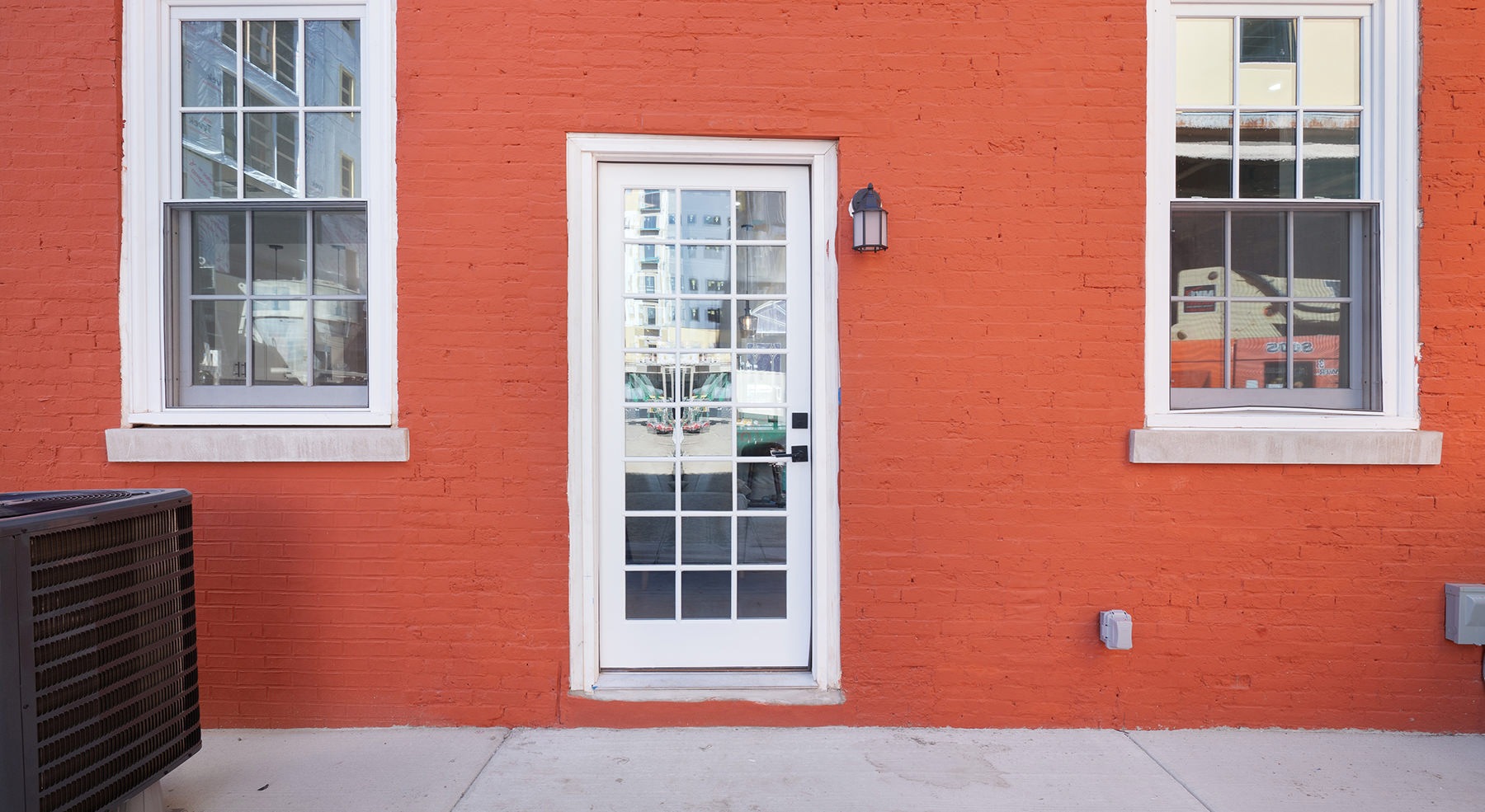 door and two windows on an orange wall
